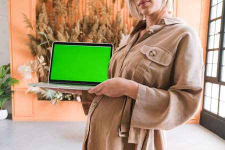 A laptop computer with a green screen image on which a pregnant girlの写真素材