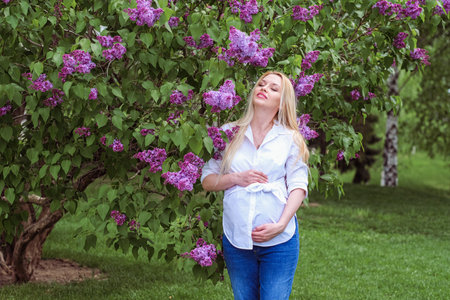 belly pregnant girl in the lilac gardenの写真素材