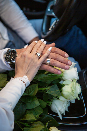 Hands of the groom and the bride on a wedding bouquet. High quality photoの写真素材