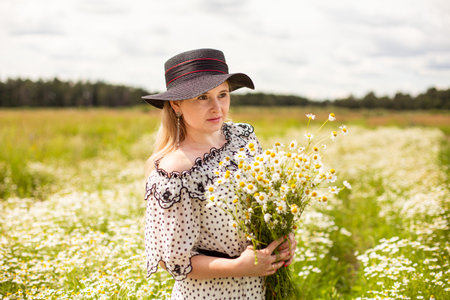 Beautiful woman in the field with flowers.の写真素材