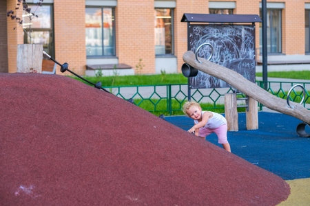 Young girl playing and sliding down a slideの写真素材