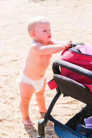 Baby walking on beach with arms outstretchedの写真素材