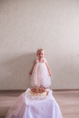 Baby girl celebrating her birthday with birthday cakeの写真素材