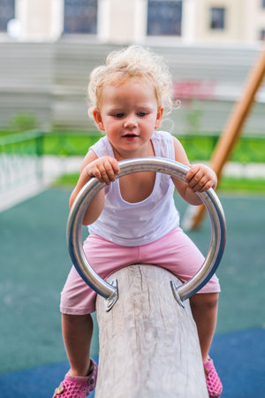 Little cute smiling girl on the childrens outdoor playgroundの写真素材