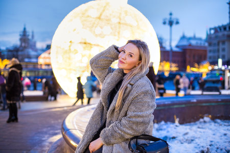 happy smiling lady poses at a street holiday fairの写真素材