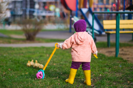 Cute baby girl with ducklings. High quality photoの写真素材