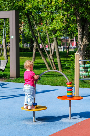 Little cute smiling girl on the children's outdoor playground. High quality photo