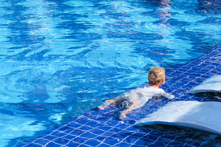Cute little girl having fun with parents in pool