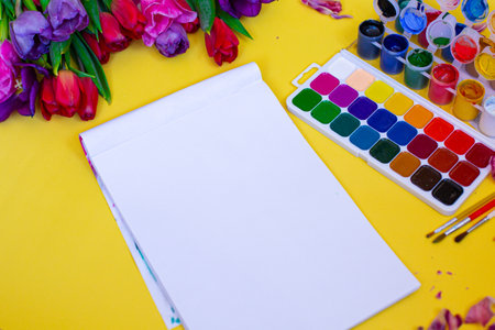 Creative layout with aquarelle palette, paint brushes on yellow background. High quality photoの写真素材