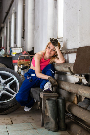Girl wearing dirty clothes posing in the workshop. High quality photoの写真素材