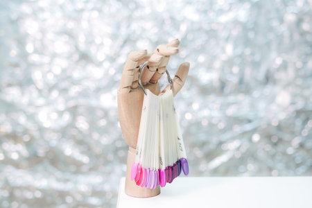 A hand holding a set of nail polish brushes. The brushes are pink and purple. Concept of creativity and self-expressionの写真素材