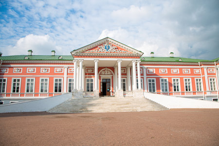 A large red building with white pillars and a green roof. The building has a lot of windows and a grand entranceの写真素材