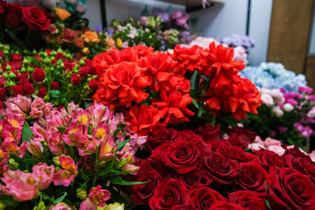 A bouquet of flowers with a variety of colors including red, pink, and blue. The arrangement is full and vibrant, creating a cheerful and lively atmosphereの写真素材