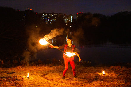 moscow, russia, 29.04.2021 A man is holding a flaming torch in a field