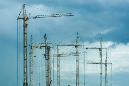 Moscow, Russia, 08/18/2025 Many tower cranes against a cloudy sky. Industrial construction site for urban development. Building new homes and infrastructure.の写真素材