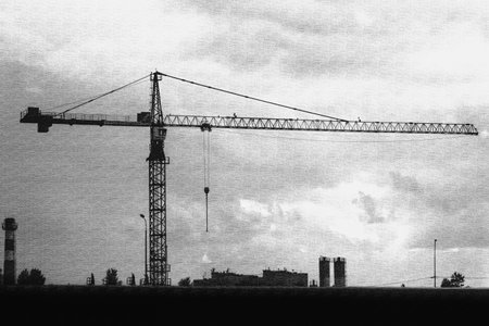 Tower crane silhouette on cloudy sky, symbolizing urban development and industrial progress. Monochrome construction concept.の写真素材