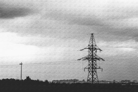 High voltage transmission tower under a cloudy sky. Electrical power line grid infrastructure. Energy and electricity concept for industrial use.の写真素材