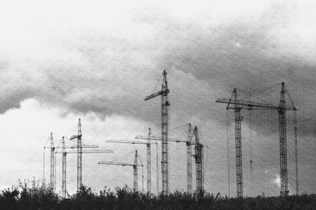 Moscow, Russia, 08/18/2025 Multiple monochrome tower cranes on horizon under murky sky. Industrial construction site for urban development. Building engineering tools.の写真素材