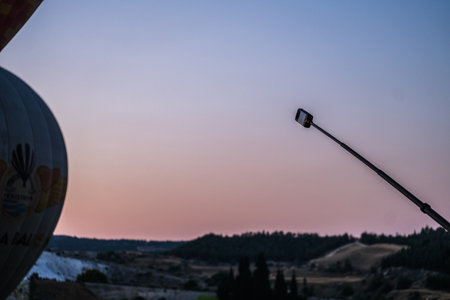 pamukkale, Turkiye, 07/08/2025 Hot air balloon and a 360 camera on a stick captures the scenic landscape during a beautiful sunset in Cappadocia, Turkey.の写真素材