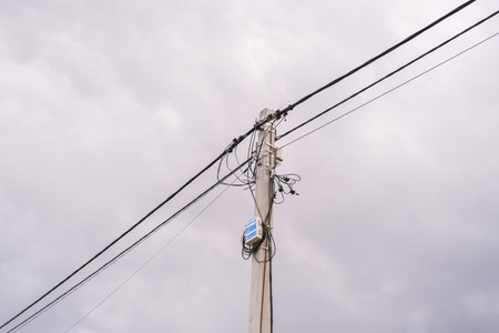 Russia, Saint Petersburg, 08/23/2025 Electric pole with wires and cables against a cloudy sky, illustrating power infrastructure and utility lines for energy distribution.の写真素材