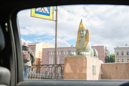 Russia, Saint Petersburg, 08/23/2025 View from car window with a man on a bridge looking at a sphinx...