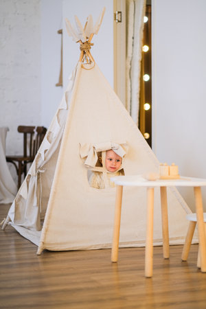 Little girl in a play tent for childhood fun and development. Early learning concept for kids...