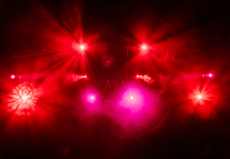 The red light from the spotlights through the smoke at the theater during the performance. Lighting equipment.の写真素材