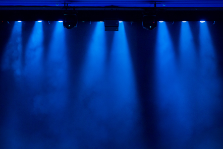 The blue light from the spotlights through the smoke in the theatre during the performance. Lighting equipment.の写真素材
