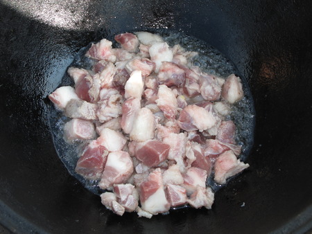 Roasting of fatty pieces of meat in the pot for cooking plov.の写真素材