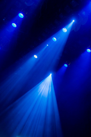 The blue light from the spotlights through the smoke in the theatre during the performance. Lighting equipment.の写真素材