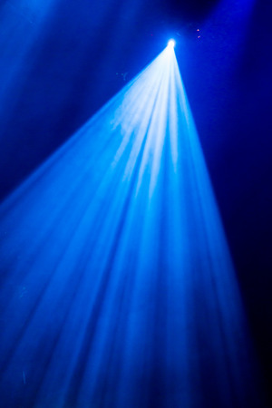 The blue light from the spotlights through the smoke in the theatre during the performance. Lighting equipment.の写真素材