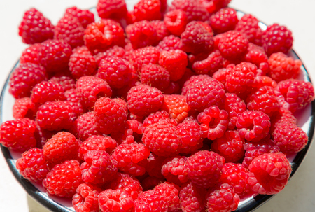 Lots of ripe raspberries. Bright crimson berries. Harvest.の写真素材