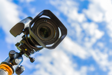 Digital camera closeup on a background of sky and clouds. Shooting on location and nature.の写真素材