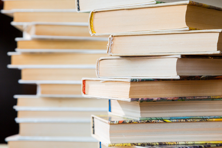 A stack of books in multicolored covers in the library or bookstore.の写真素材