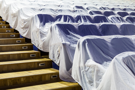 Chairs in the auditorium, covered with a white cloth to protect from dust and dirt.の写真素材