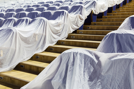 Chairs in the auditorium, covered with a white cloth to protect from dust and dirt.の写真素材