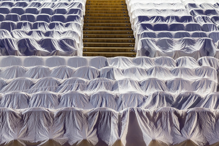 Chairs in the auditorium, covered with a white cloth to protect from dust and dirt.の写真素材