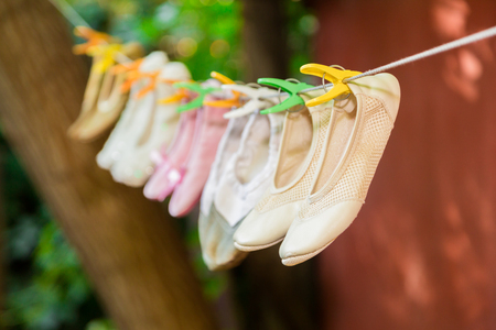 Children's ballet shoes are drying on a rope.の写真素材
