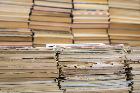 A stack of old school notebooks and a stack of textbooks or books.の写真素材