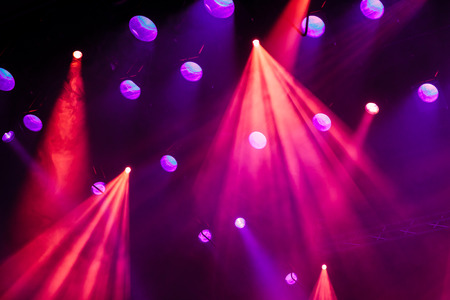 Lighting equipment on the stage during the performance. The light from the spotlight through the smoke. Red and purple beams.の写真素材