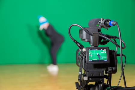 Actress in theatrical costume in a Television Studio. Green screen and chroma key. Lighting equipment and filming equipment.の写真素材
