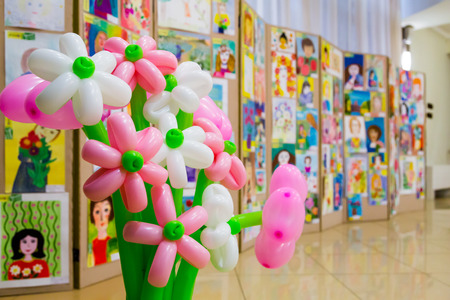 Competition of children's drawings. Exhibition of children's art. Colorful balloons in the foreground. Defocused background.の写真素材