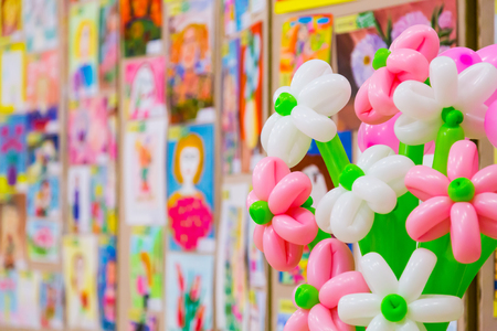 Competition of children's drawings. Exhibition of children's art. Colorful balloons in the foreground. Defocused background.の写真素材