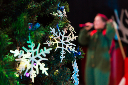 Decorated Christmas tree. Toys and lace snowflakes. New year. The actor with the microphone in the backgroundの写真素材