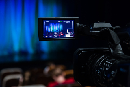 The LCD display on the camcorder. Videography in the theater. Blue-green curtain on the stage.の写真素材