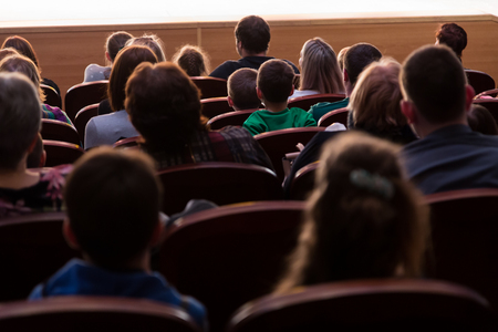 People, parents with children in the audience. Sold out. Shooting from the back.の写真素材