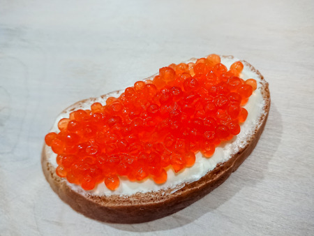Sandwich with red caviar. White bread with butter. Seafood delicacies.の写真素材