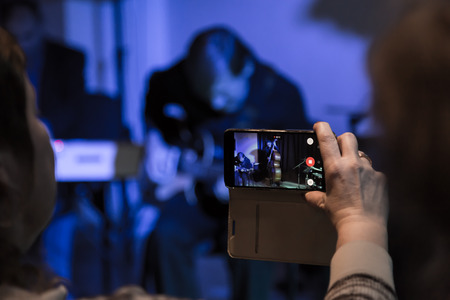 Video shooting with your smartphone. Filming of the concert. Musicians playing the double bass and electric guitar.の写真素材