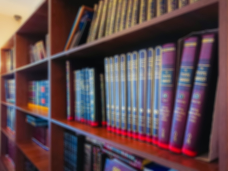 Defocused image. Multi-colored books on the bookshelf in the library. The bokeh effect.の写真素材