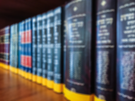 Defocused image. Multi-colored books on the bookshelf in the library. The bokeh effect.の写真素材